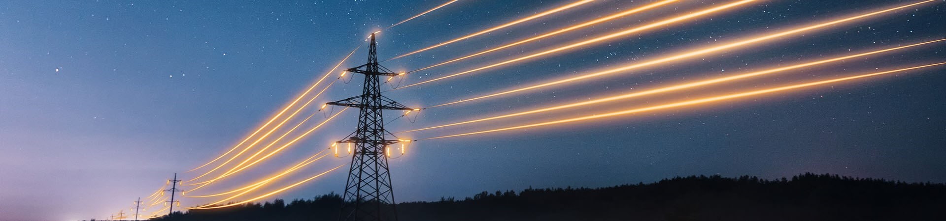 Transmission tower against a night sky, emitting orange streaks of light down the transmission wires symbolizing electricity flow.